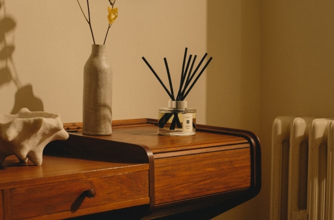 Jo Malone London Diffuser on wooden table with vase & flowers