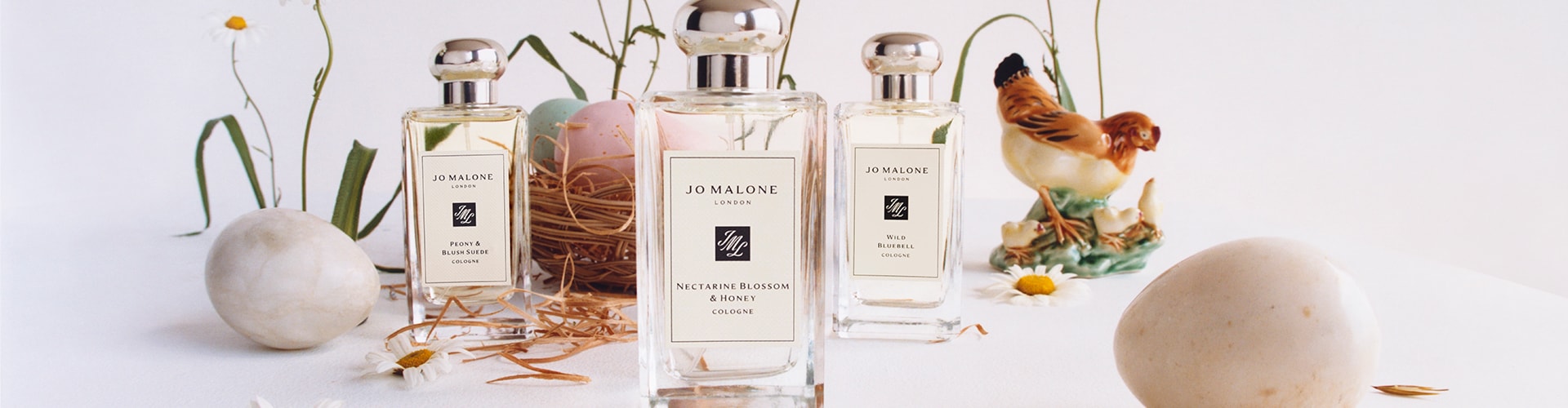 Three Jo Malone London colognes surrounded by flowers chicks and eggs